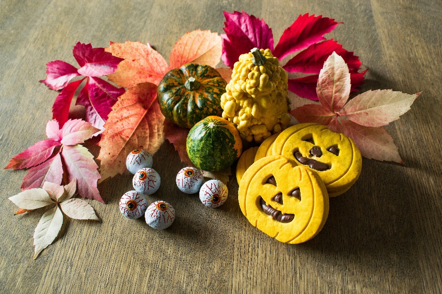 Apsveikuma e-kartiņa Halloween tēmas saldumi ar koka lapām uz galda