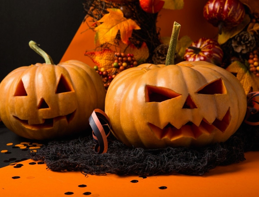 Greeting e-card Halloween pumpkins on an orange background