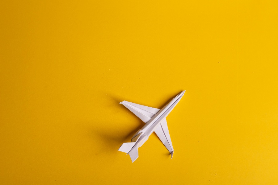 Apsveikuma e-kartiņa Papīra lidmašīna uz dzeltena fona