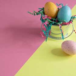 Trīs krāsu lieldienas olas uz rozā dzeltena fona
