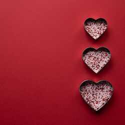 Trīs sirds formiņas uz sarkana fona