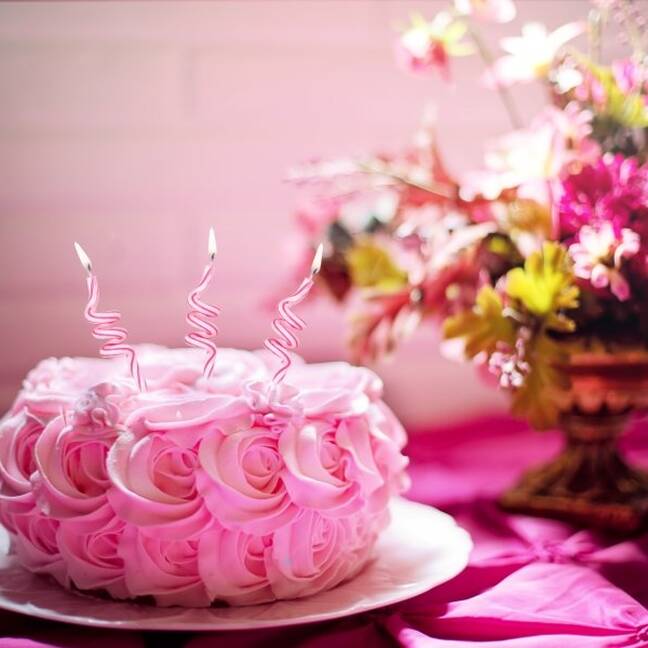 Pink cake with candles and flowers e-card